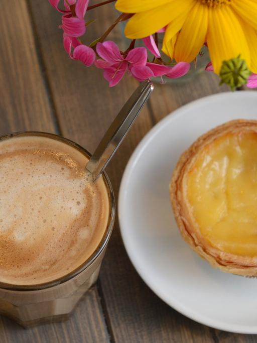 Ein Cafe cortado und ein Pastel de Nata, ein Blätterteigtörtchen mit Pudding, stehen am 07.09.2013 in Berlin auf einem Tisch im Cafe "Kahrmanns Own" in der Bötzowstraße im Berliner Bezirk "Prenzlauer Berg".