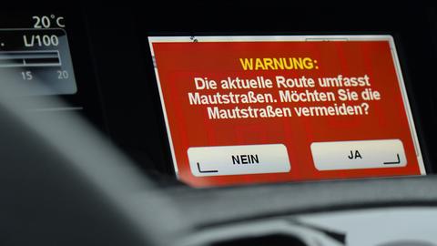 Auf einem Navigationsgerät steht die Frage: "Die aktuelle Route umfasst Mautstraßen. Möchten Sie die Mautstraßen vermeiden?