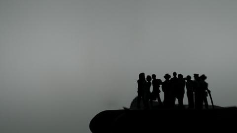 Die Silhouetten von Figuren auf einer Hand.
