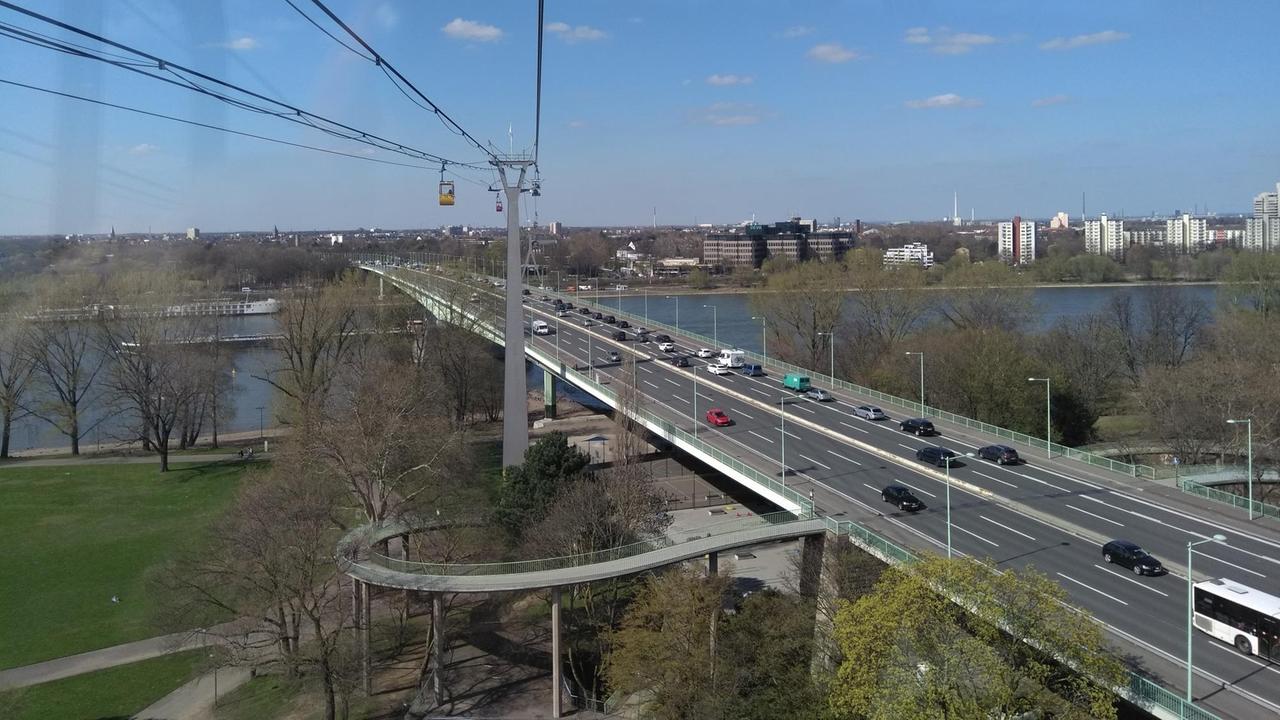 Aufnahme der Kölner Zoobrücke mit Autos, die über die Brücke fahren, darüber schwebt die Seilbahn.