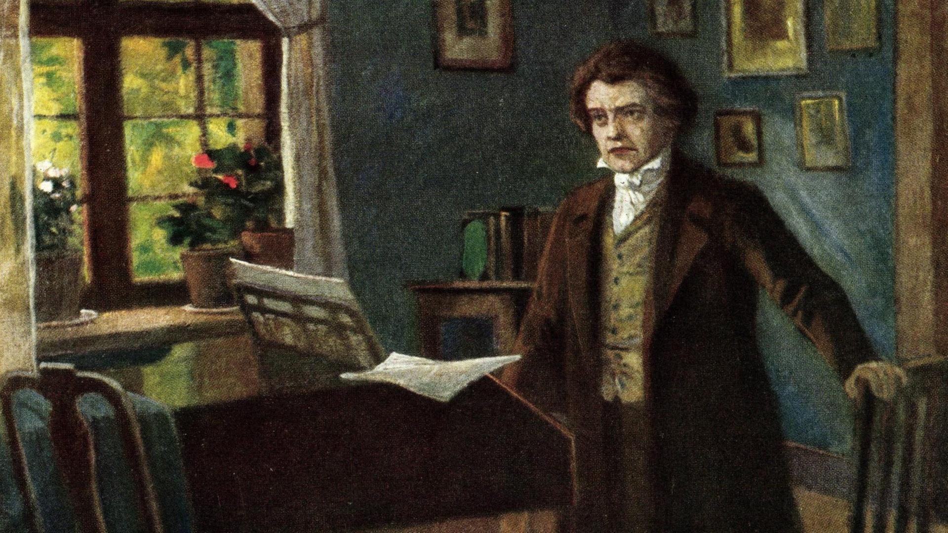 Komponist Ludwig van Beethoven steht in einem Zimmer mit einem Flügel im Hintergrund.