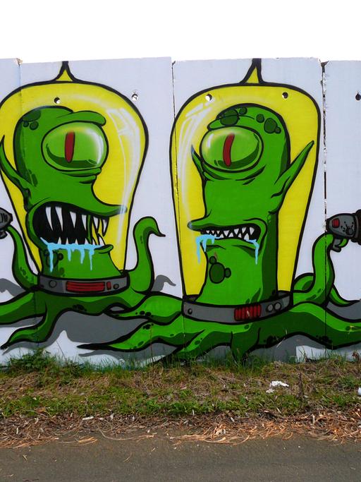 Zwei Außerirdische aus der Comic-Fernsehserie "Die Simpsons" an Mauersegmenten in Berlin