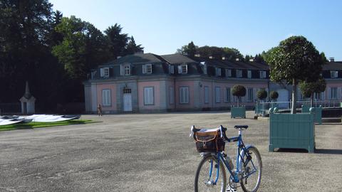Ein Fahrrad steht an einem sonnigen Tag im Park von Schloss Benrath, Düsseldorf