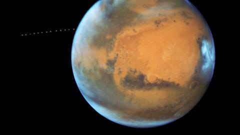 Ferner Nachbar: Mars und sein Mond Phobos (Serienaufnahme), fotografiert vom Hubble-Weltraumteleskop. Der Mars (im Hintergrund der Mond Phobos) zieht in den kommenden Tagen am Stern Antares vorbei.
