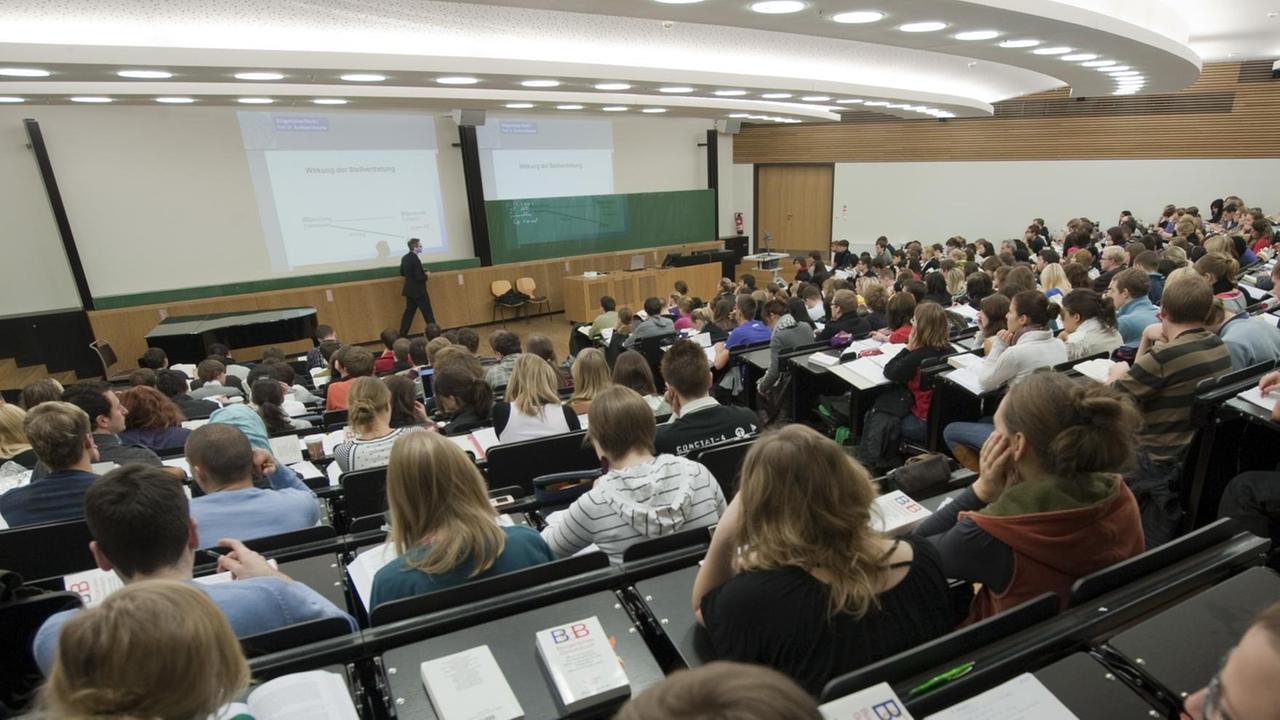 Studenten verfolgen in einem Hörsaal auf dem neuen Campus der Universität Leipzig eine Juravorlesung.