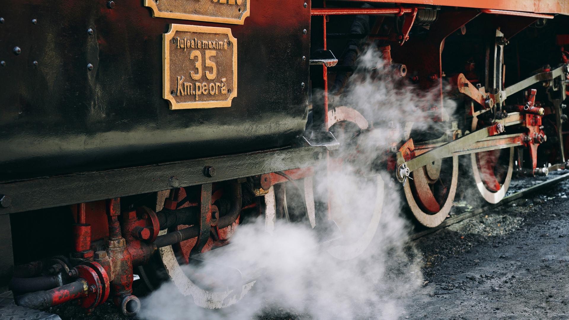 Eine alte Dampflokomotive fährt auf Schienen.