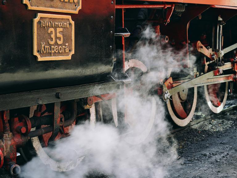 Eine alte Dampflokomotive fährt auf Schienen.