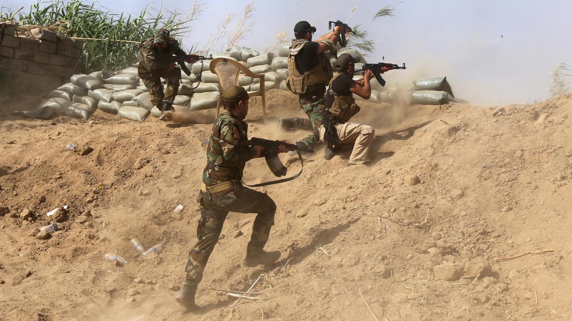 Sunnitische Kämpfer im Irak kämpfen mit Regierungstruppen nahe einer Ölraffinerie etwa 200 Kilometer nördlich von Bagdad.