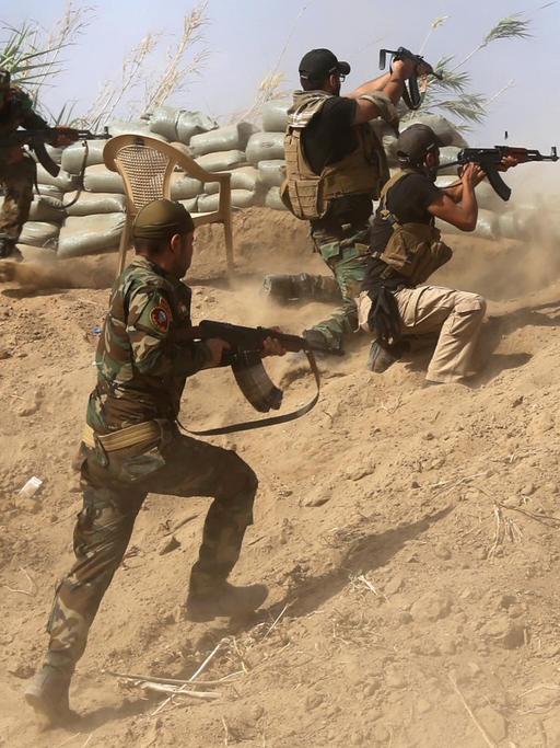 Sunnitische Kämpfer im Irak kämpfen mit Regierungstruppen nahe einer Ölraffinerie etwa 200 Kilometer nördlich von Bagdad.