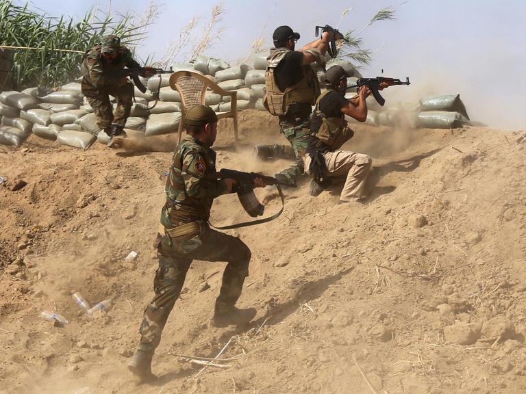 Sunnitische Kämpfer im Irak kämpfen mit Regierungstruppen nahe einer Ölraffinerie etwa 200 Kilometer nördlich von Bagdad.