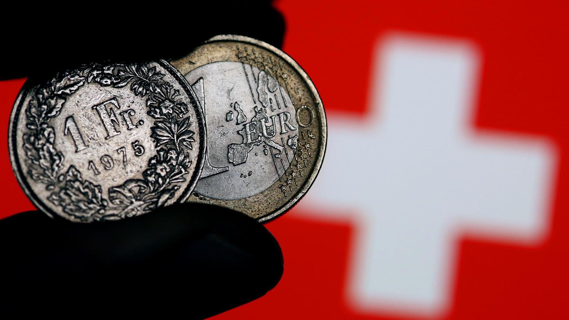 Eine Euro-Münze und ein Schweizer Franken