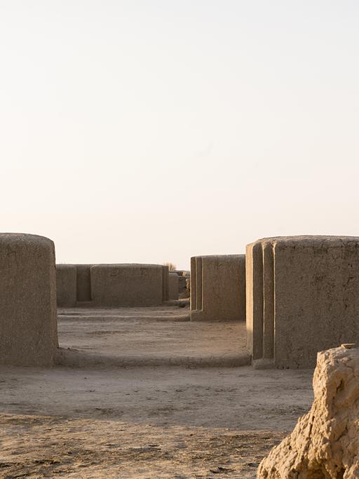 Eine Ansammlung von Lehmmauern auf Wüstensand
