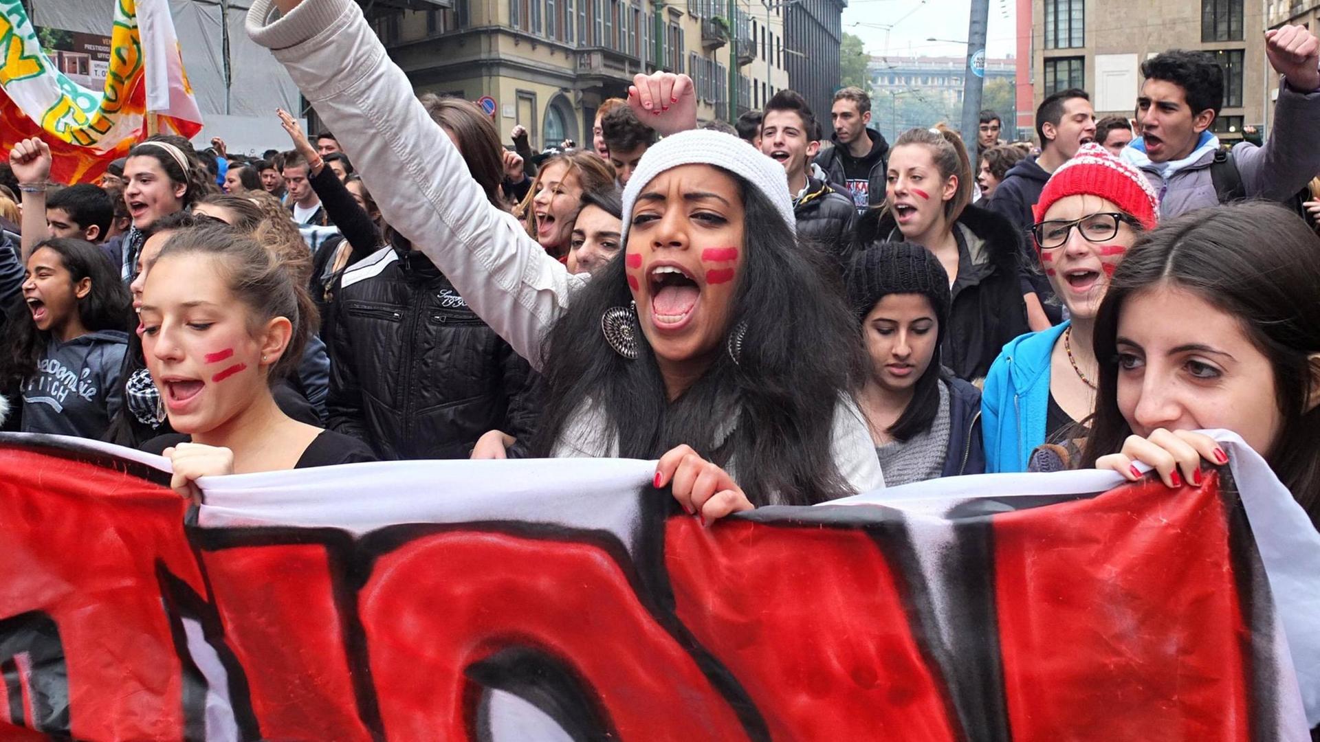 Farbfoto: aufgebrachte Studierende protestieren mit Plakaten in der Hand