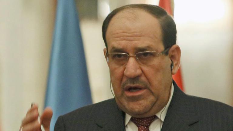 Nuri al-Maliki, bisheriger Ministerpräsident des Irak, gestikuliert vor zwei Flaggen.