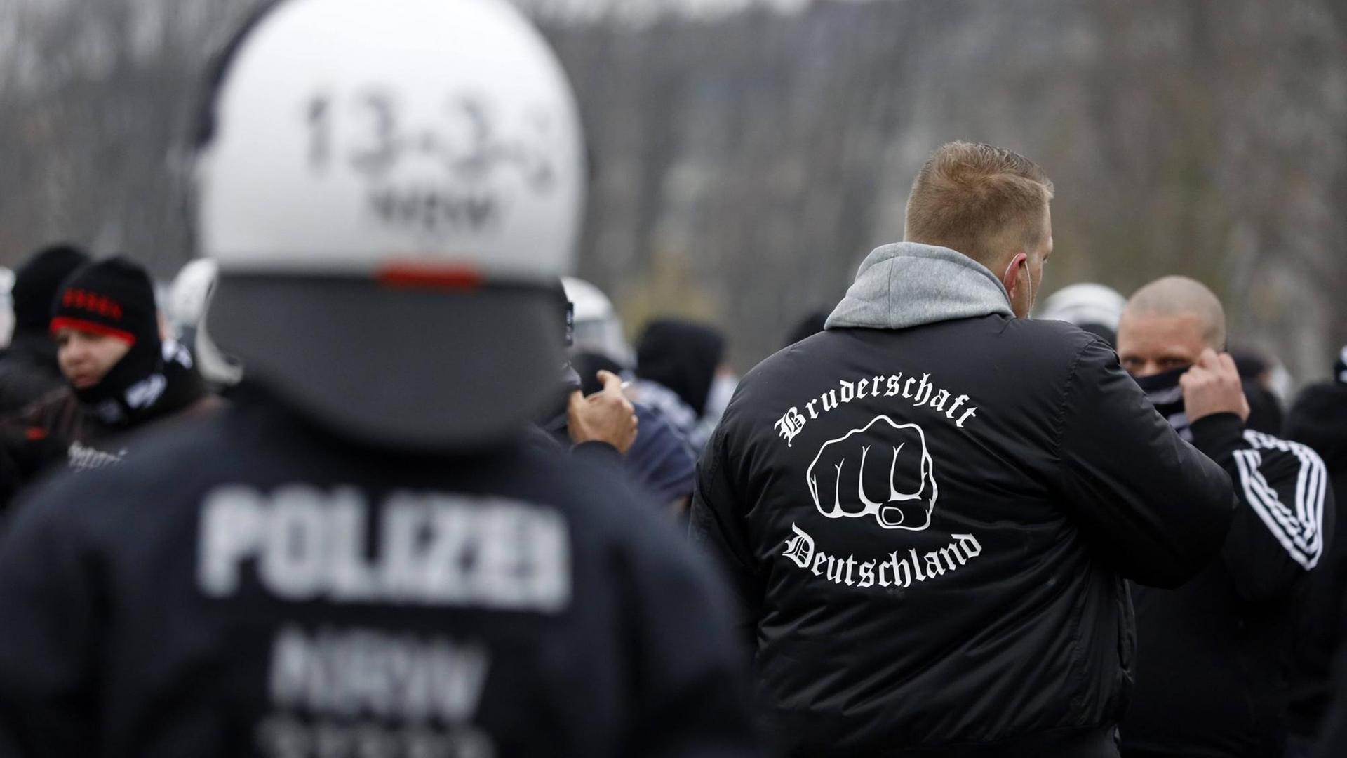 Polizisten kesseln eine Gruppe Hooligans auf der Querdenken-Demo im Rheinpark Golzheim ein. Ein Demonstrant trägt eine Jacke mit der Aufschrift "Bruderschaft Deutschland": Eine neonazistische Gruppierung, die hauptsächlich in Düsseldorf tätig ist.