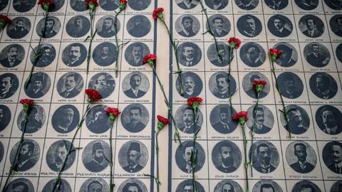 Sie sehen Fotos von ermordeten armenischen Intellektuellen, darauf rote Nelken.
