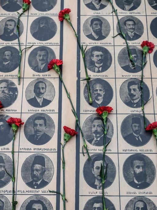 Sie sehen Fotos von ermordeten armenischen Intellektuellen, darauf rote Nelken.
