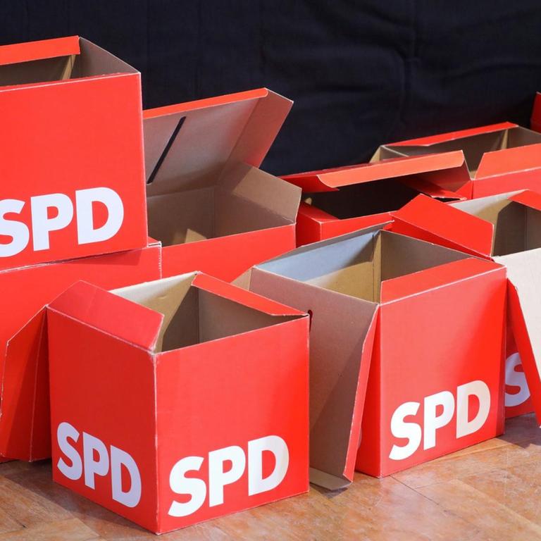Leere Stimmzettel-Boxen stehen beim SPD-Landesparteitag vor der Bühne. 