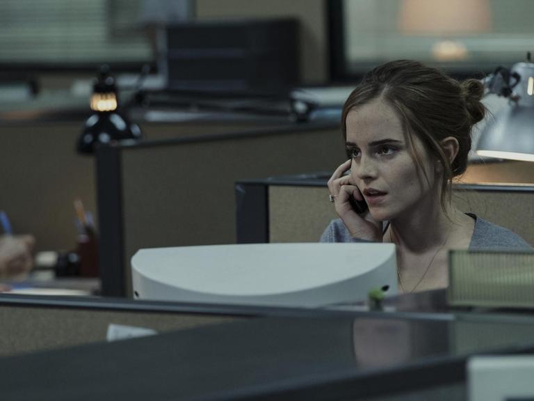 Szenenfoto: Mae (Emma Watson) sitzt in einem tristen Großraumbüro
