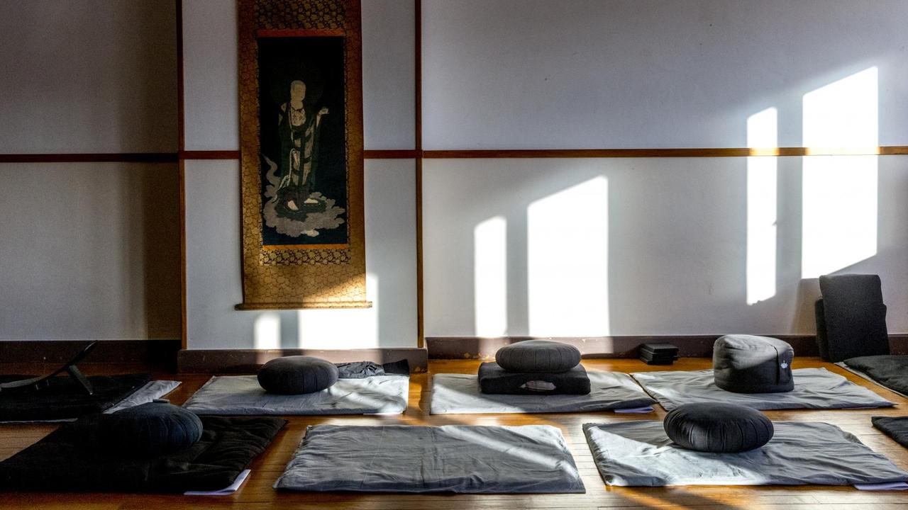 In einem Raum eines Zen-Retreats liegen Kisssen und Matten bereit.