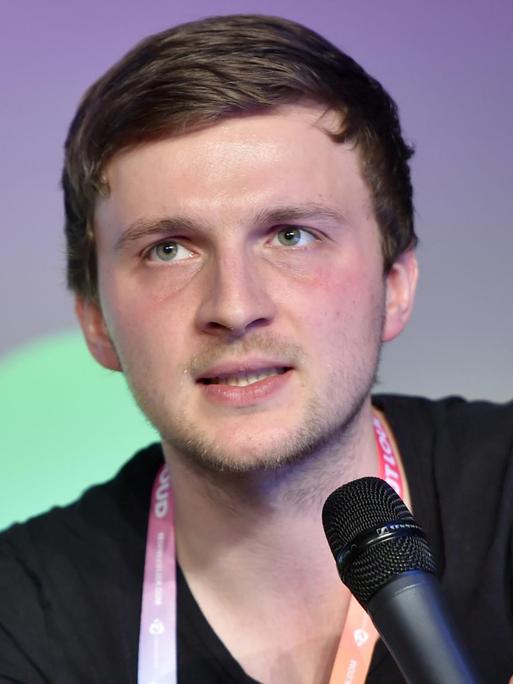 Der Journalist Daniel Moßbrucker mit einem Mikrofon in der Hand