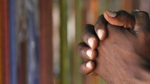 Christian man praying god. Close-up on hands. Lome. Togo. | Verwendung weltweit