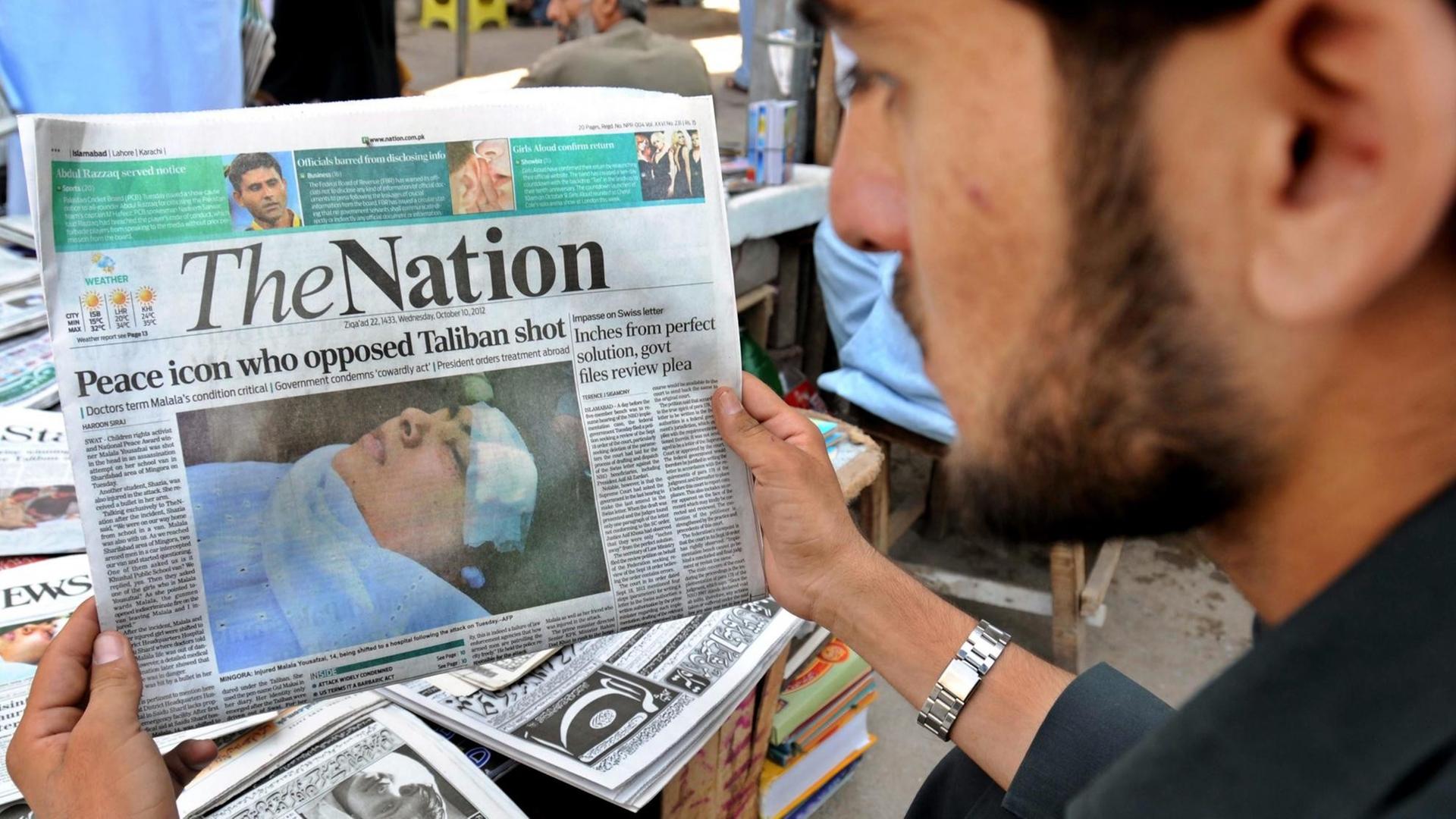 Ein Mann hat eine Ausgabe der englischsprachigen Tageszeitung "The Nation" in der Hand, die in Pakistan erscheint.