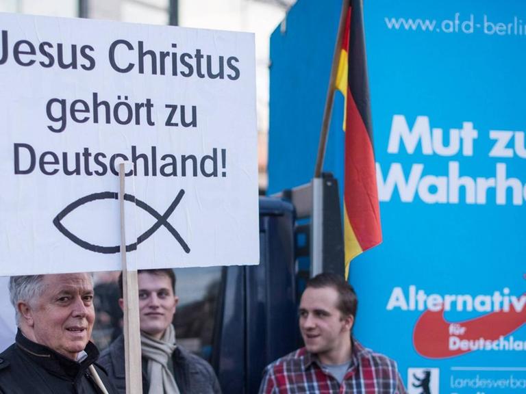 AfD Anhänger mit einem Schild "Jesus Christus gehört zu Deutschland".