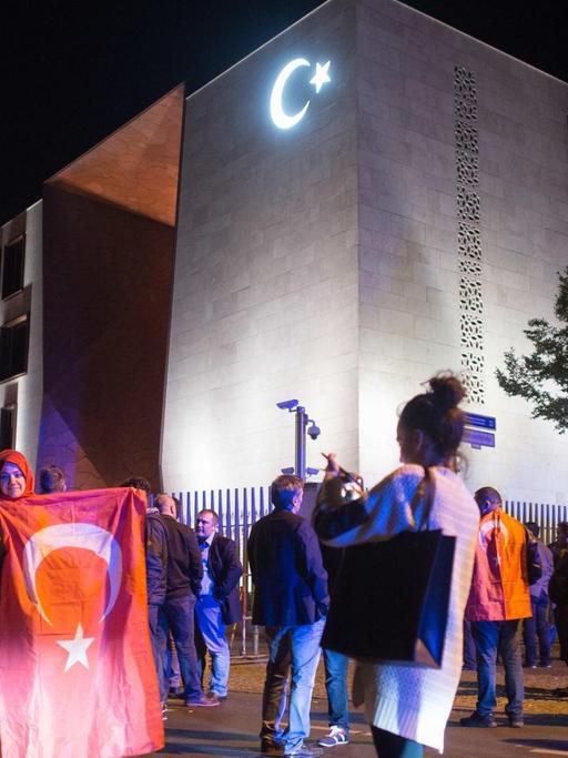 Beschreibung:Demonstranten mit türkischen Fahnen stehen am 16.07.2016 vor der türkischen Botschaft in Berlin am Rande einer Versammlung und machen ein Erinnerungsfoto. Vor der Botschaft hatten sich hunderte Menschen zu einer Demonstration gegen den Militärputsch in der Türkei versammelt.