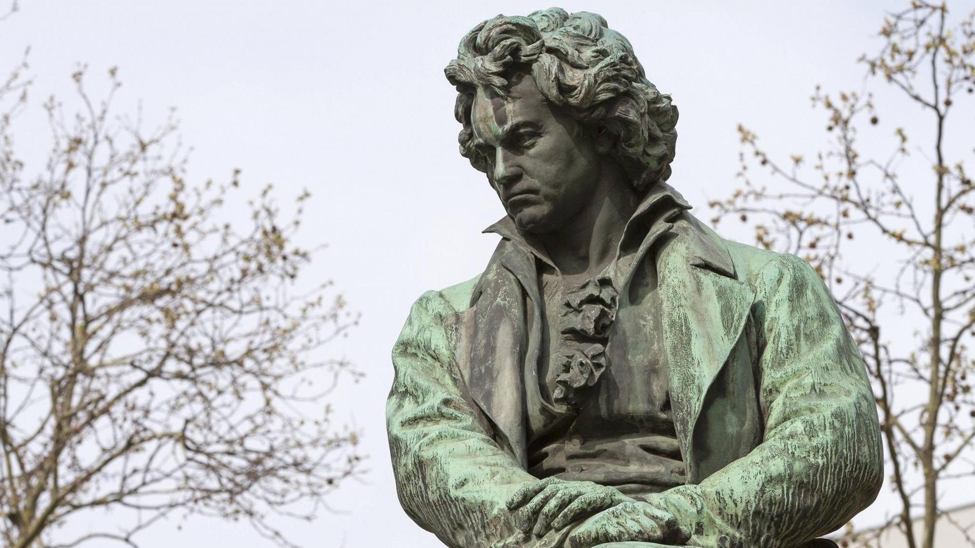 Eine Beethoven-Figur, die zwischen Bäumen steht.