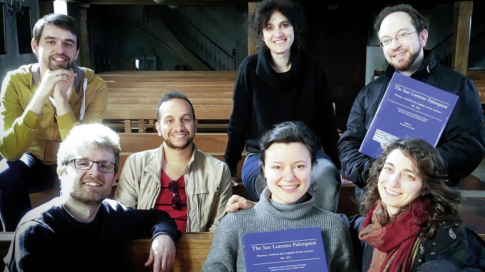 Die 7 Mitglieder des Schweizer Ensembles La Morra, zwei von ihnen halten eine Ausgabe des neu veröffentlichten San Lorenzo Palimpsests in der Hand