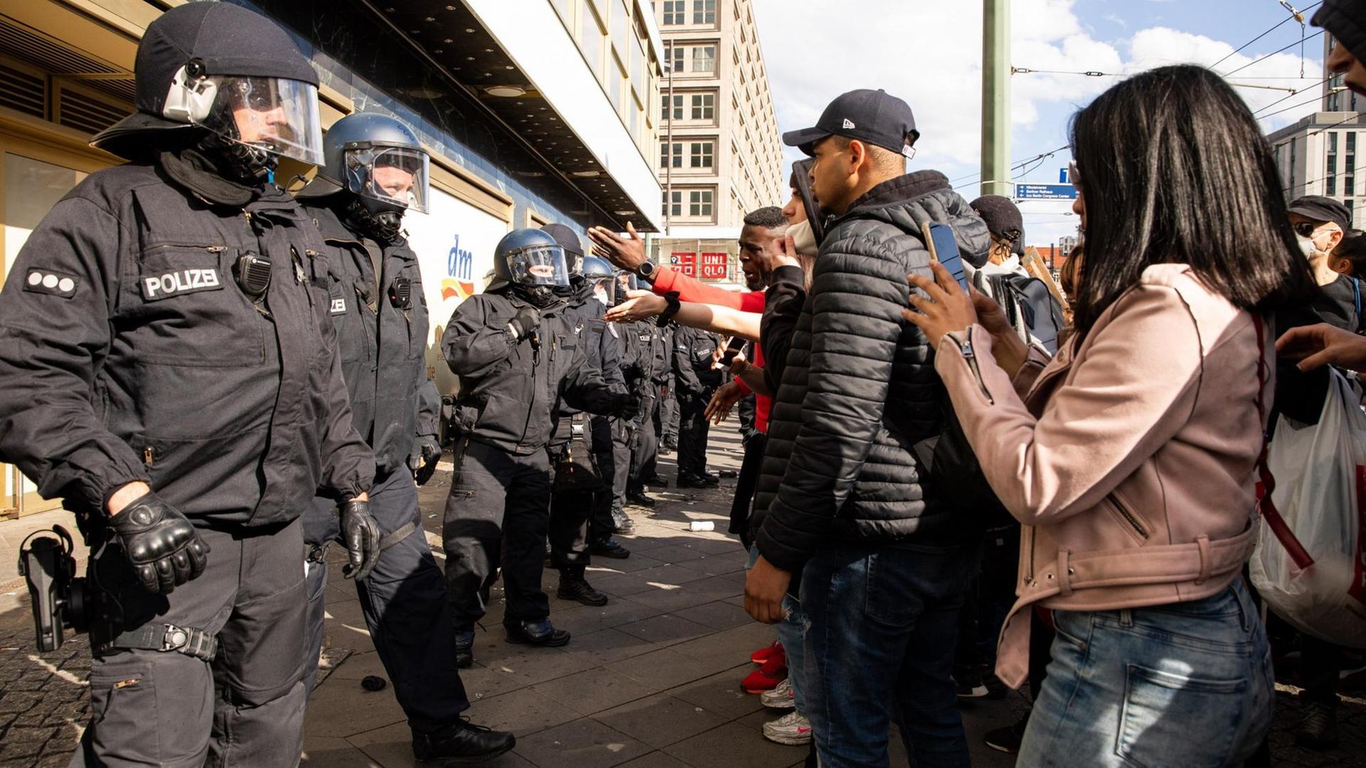 Polizisten und schwarze Demonstranten stehen sich in Berlin gegenüber.