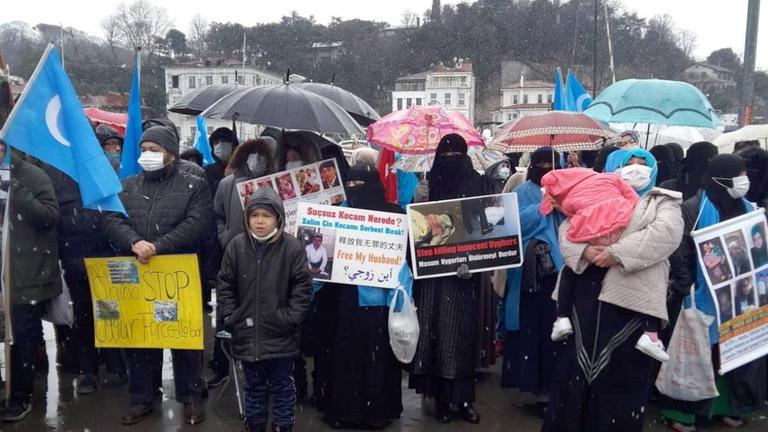 Mitglieder der uigurischen Gemeinschaft, die in der Türkei leben, halten Bilder von vermissten Familienmitgliedern hoch und skandieren «China Stop Genocide» («China, stoppe den Genozid») in der Nähe des chinesischen Konsulats.