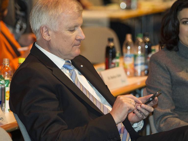 Horst Seehofer, CSU, tippt etwas in sein Smartphone.
