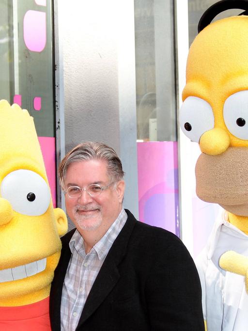 Simpsons-Erfinder Matt Groening (M.) mit den beiden Simpsons-Charakteren Bart (l.) und Homer (r.) im Jahr 2012 bei der Ehrung mit einem Stern auf dem Walk of Fame.