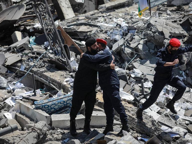 Israel-Palestinian Ceasefire Palestinian policemen walk on the rubble of Arafat City, Gaza s police headquarters in Gaza City on May 22, 2021, following a ceasefire between Israel and Palestinian militants in the Israeli-blockaded enclave. - As the ceasefire holds, humanitarian aid began to enter the enclave ravaged by 11 days of bloodshed. While thousands of displaced Palestinians returned to their homes, and Israelis began to resume normal life a day earlier, international focus turned to the reconstruction of the bomb-shattered Gaza Strip. Gaza City Palestinian Territories Palestine fathi-notitle210522_np3Ie PUBLICATIONxNOTxINxFRA Copyright: