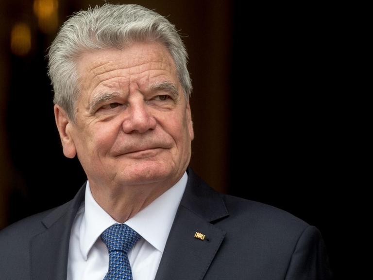 Bundespräsident Joachim Gauck in dunklem Anzug vor dunklem Hintergrund