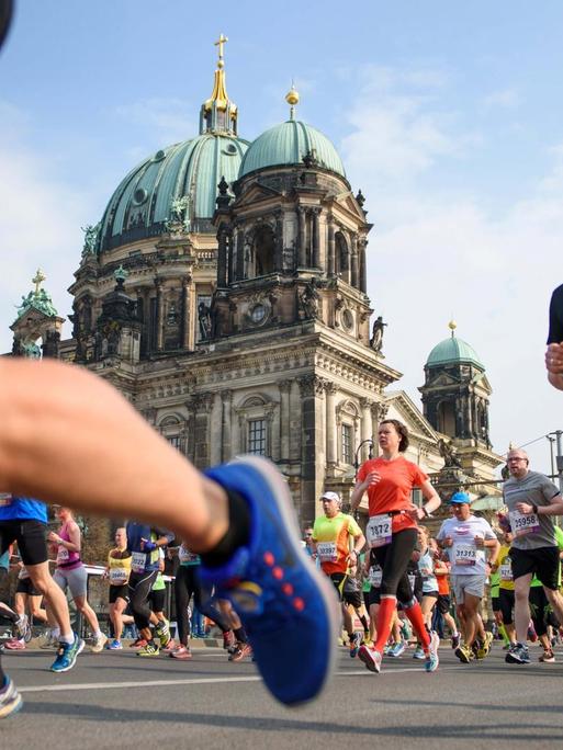 Teilnehmer laufen während des 37. Halbmarathon in Berlin am Berliner Dom vorbei.