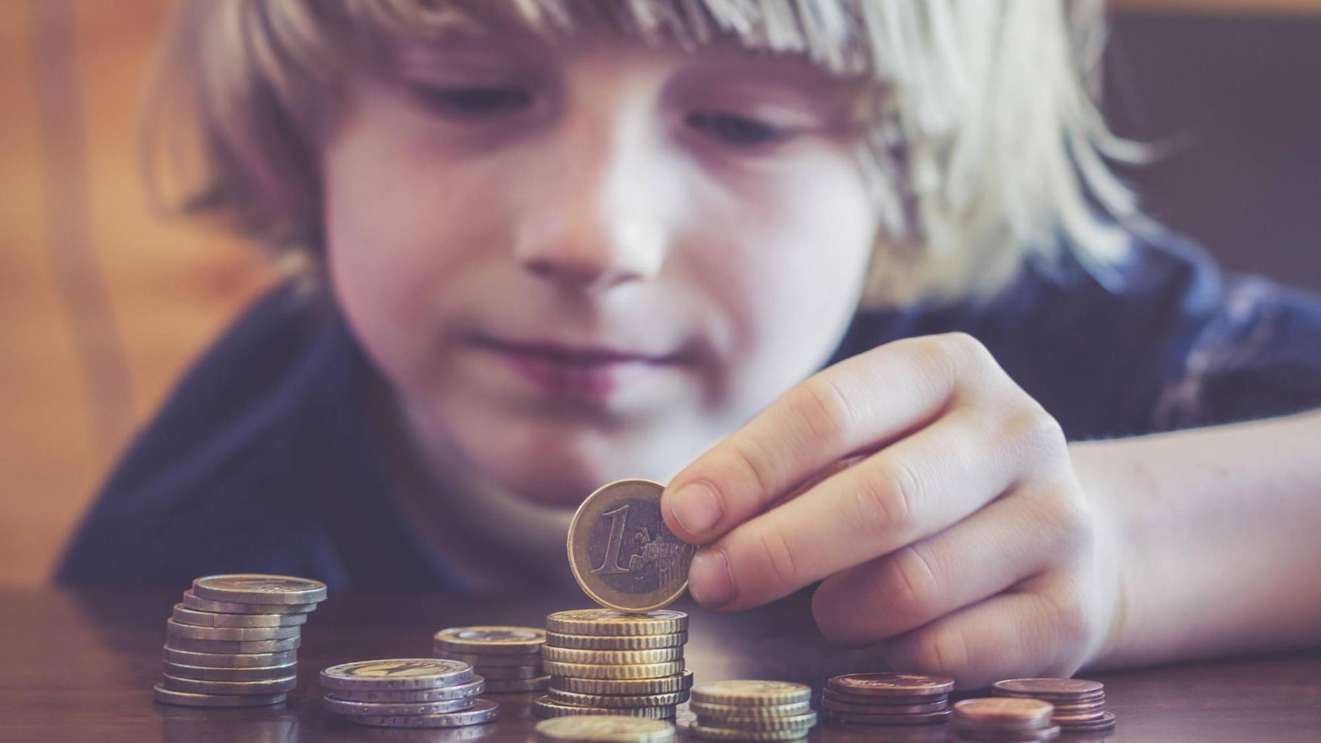 Ein Kind zählt Euromünzen.