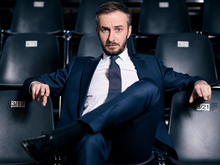 "Neo Magazin Royale": Jan Böhmermann sitzt auf einem schwarzen Stuhl. Links, rechts und hinter ihm stehen in Reihen weitere schwarze Stühle.