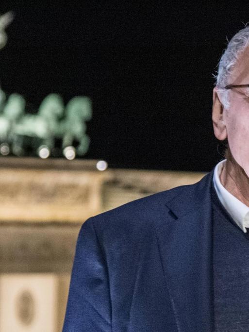 Der Schriftsteller Uwe Timm vor dem Brandenburger Tor in Berlin.