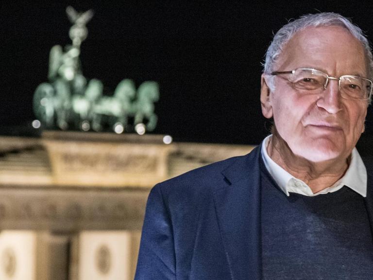 Der Schriftsteller Uwe Timm vor dem Brandenburger Tor in Berlin.