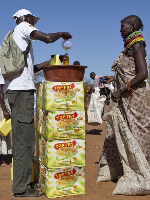 Zwei Frauen aus Kenia stehen mit großen Säcken an einer Stelle für Nahrungsmittelverteilung