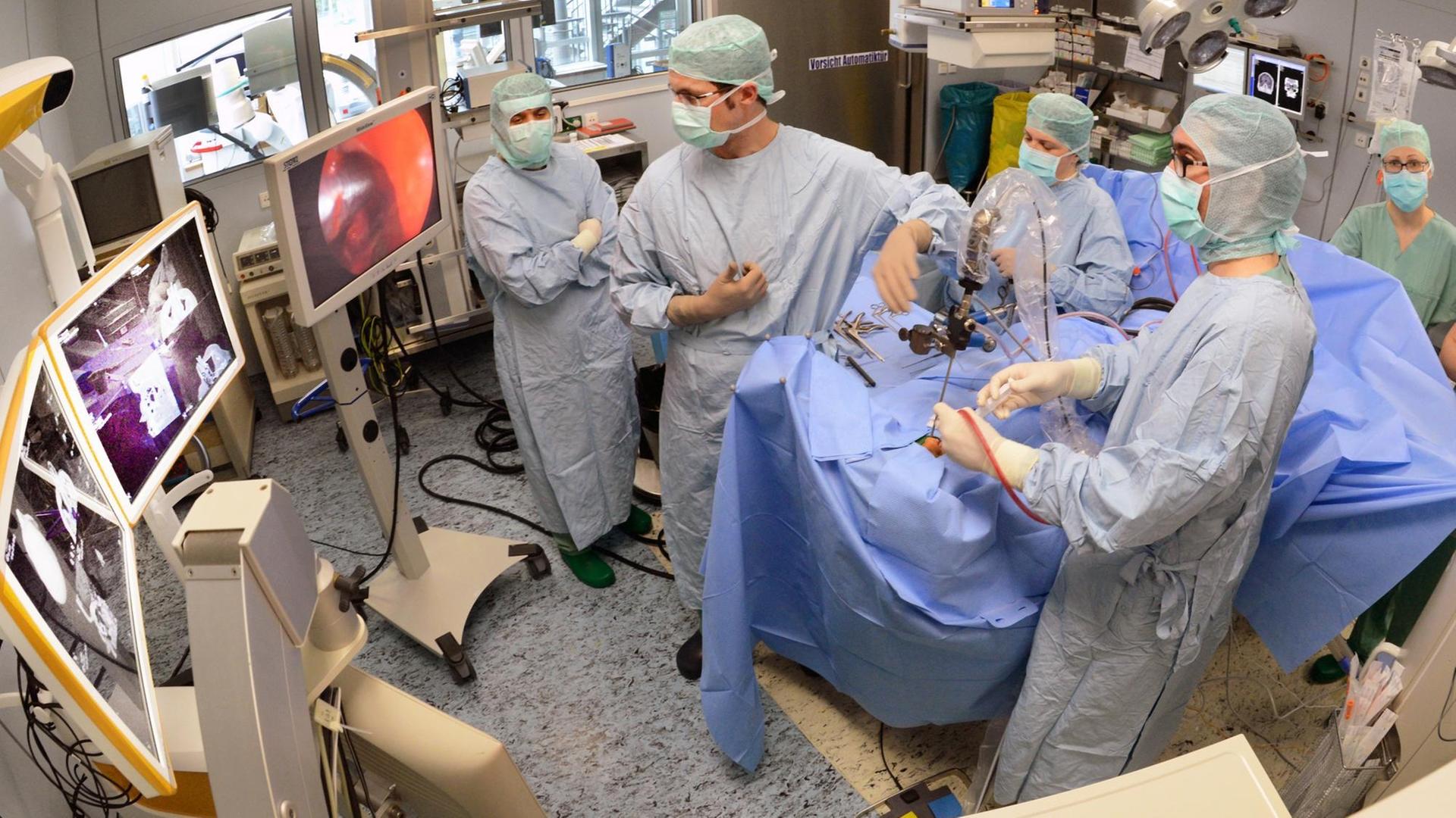 In einem Operationssaal der Kilinik für Neurochirurgie am Universitätsklinikum Leipzig operieren Oberarzt Mathias Hofer (vorn r) und OA Dirk Lindner (vorn l) einen Patienten mit einem Hirntumor, aufgenommen am 22.04.2015.