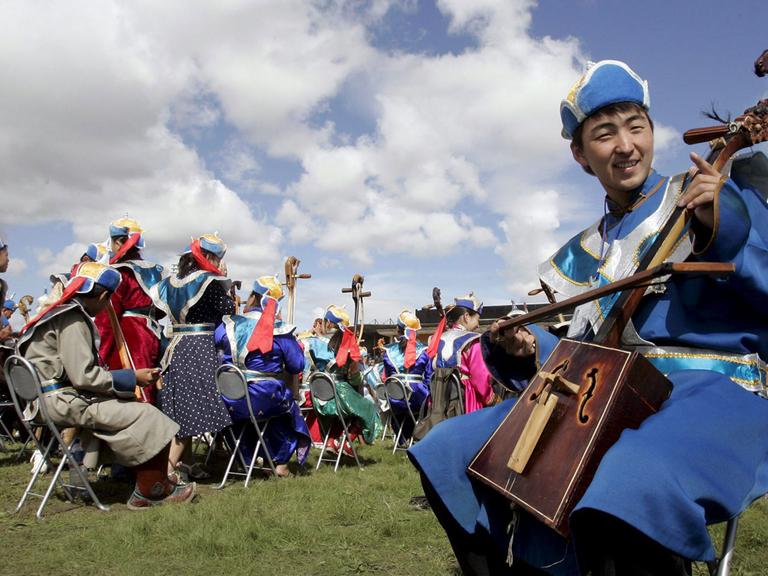 Ein Mann spielt eine traditionelle mongolische Pferdekopfgeige.