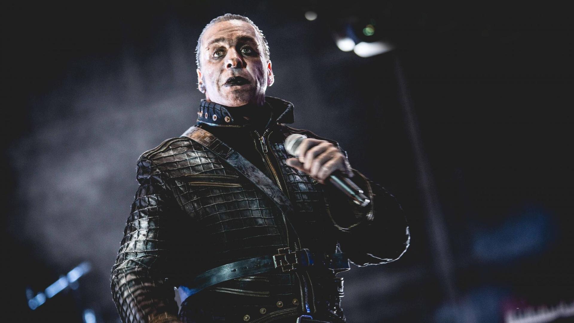 Der Sänger Till Lindemann düster geschminkt und mit Leder bekleidet steht auf der Bühne.