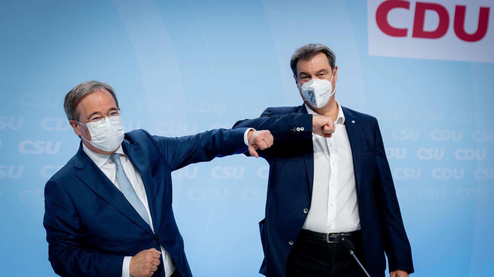 Armin Laschet (CDU, links) und Markus Söder (CSU) berühren sich coronakonform mit den Ellbogen bei der Verabschiedung des Wahlprogramms der Union für die Bundestagswahl