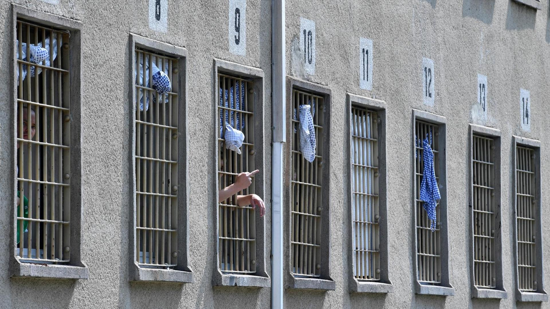 Ein Häftling steht in seiner Zelle am Fenster in der Justizvollzugsanstalt in Hohenleuben (Thüringen) und zeigt durch die Gitterstäbe den "Stinkefinger".
