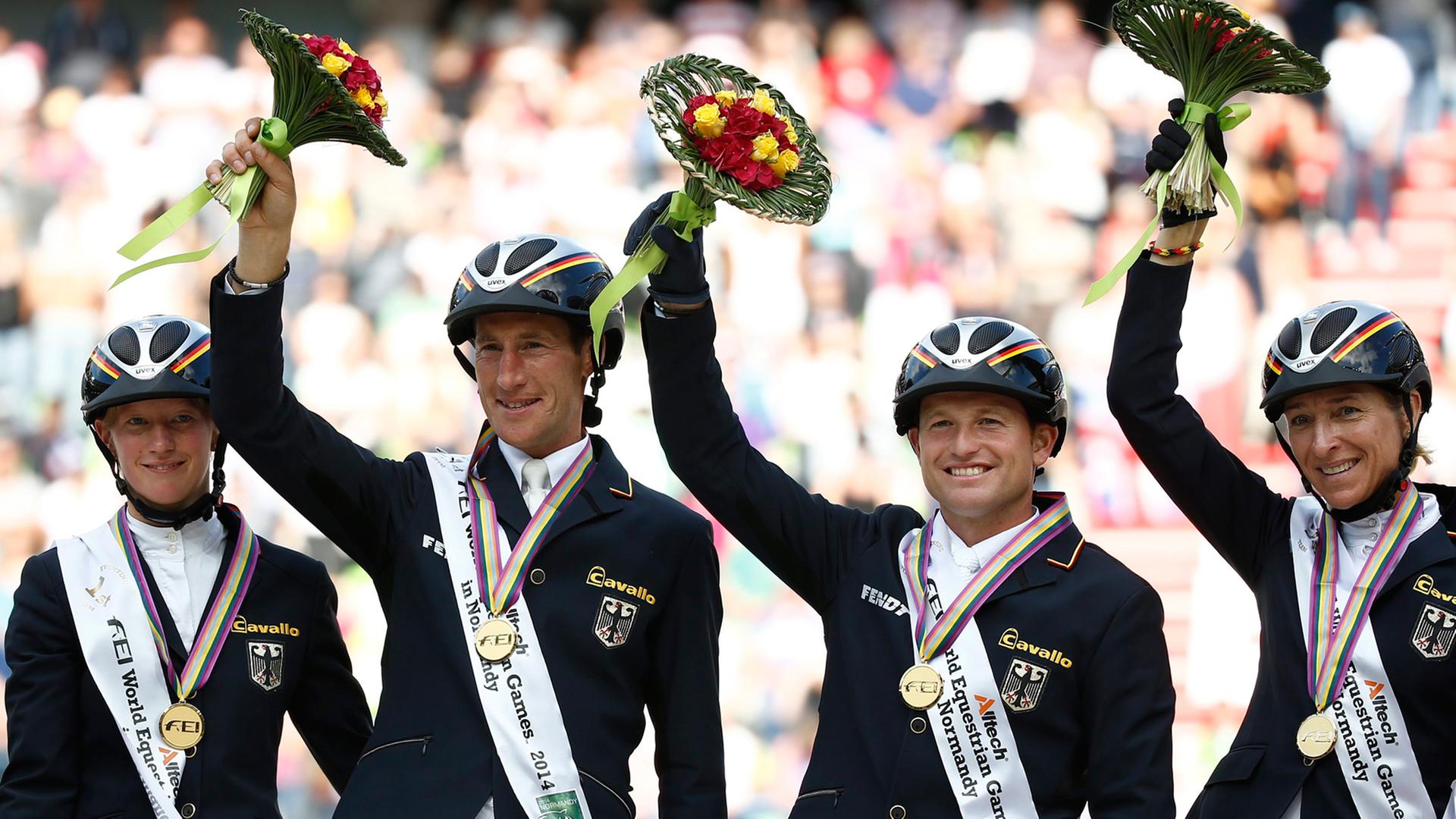 Die deutschen Vielseitigkeitsreiter Sandra Auffarth, Dirk Schrade, Michael Jung und Ingrid Klimke (von links) freuen sich über ihre Goldmedaille. Die deutschen Vielseitigkeitsreiter Sandra Auffarth, Dirk Schrade, Michael Jung und Ingrid Klimke (von links) freuen sich über ihre Goldmedaille.