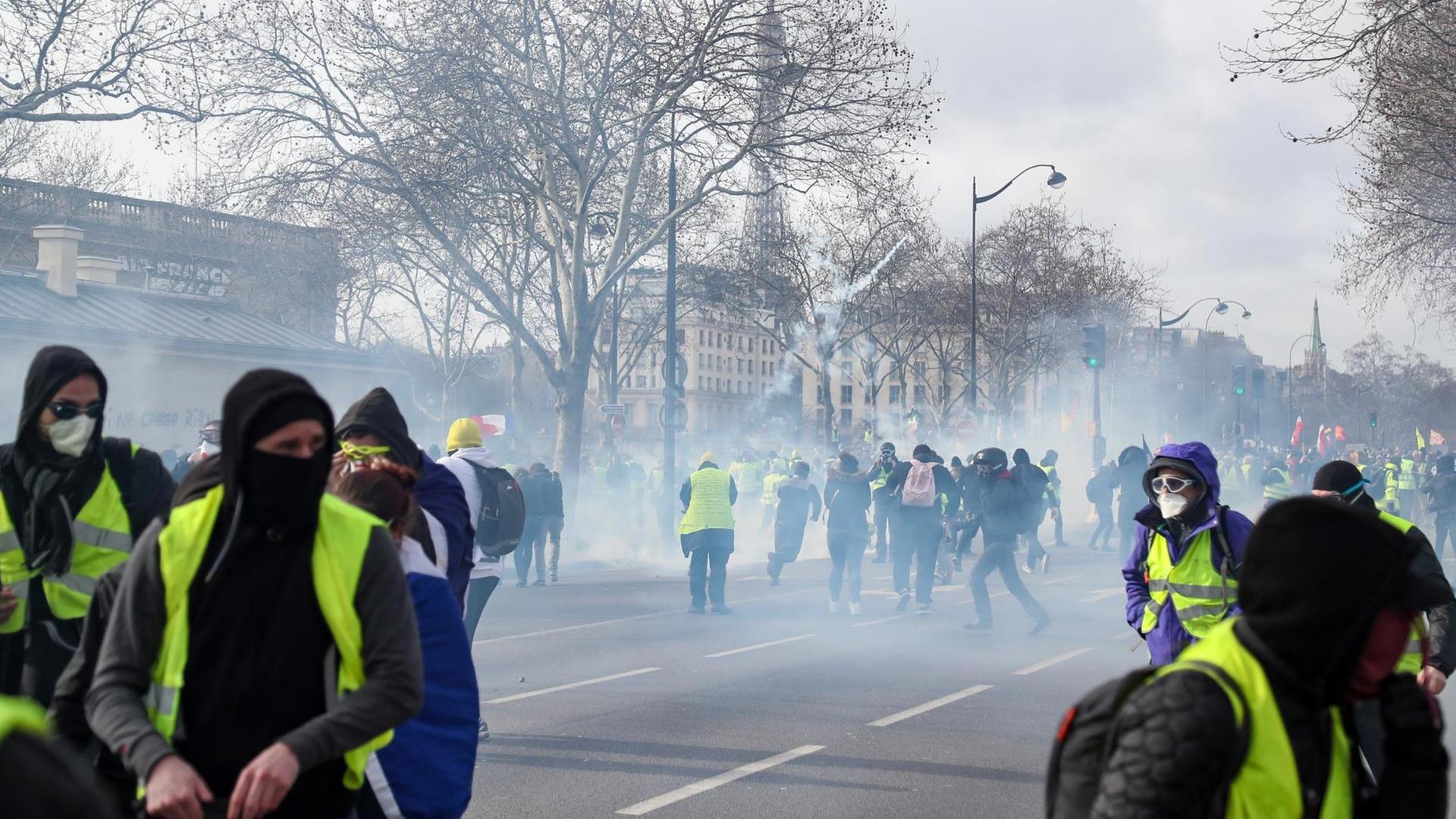 Anhänger der "Gelbwesten"-Bewegung protestieren im Tränengasnebel in der Nähe des Eifelturms in Paris.